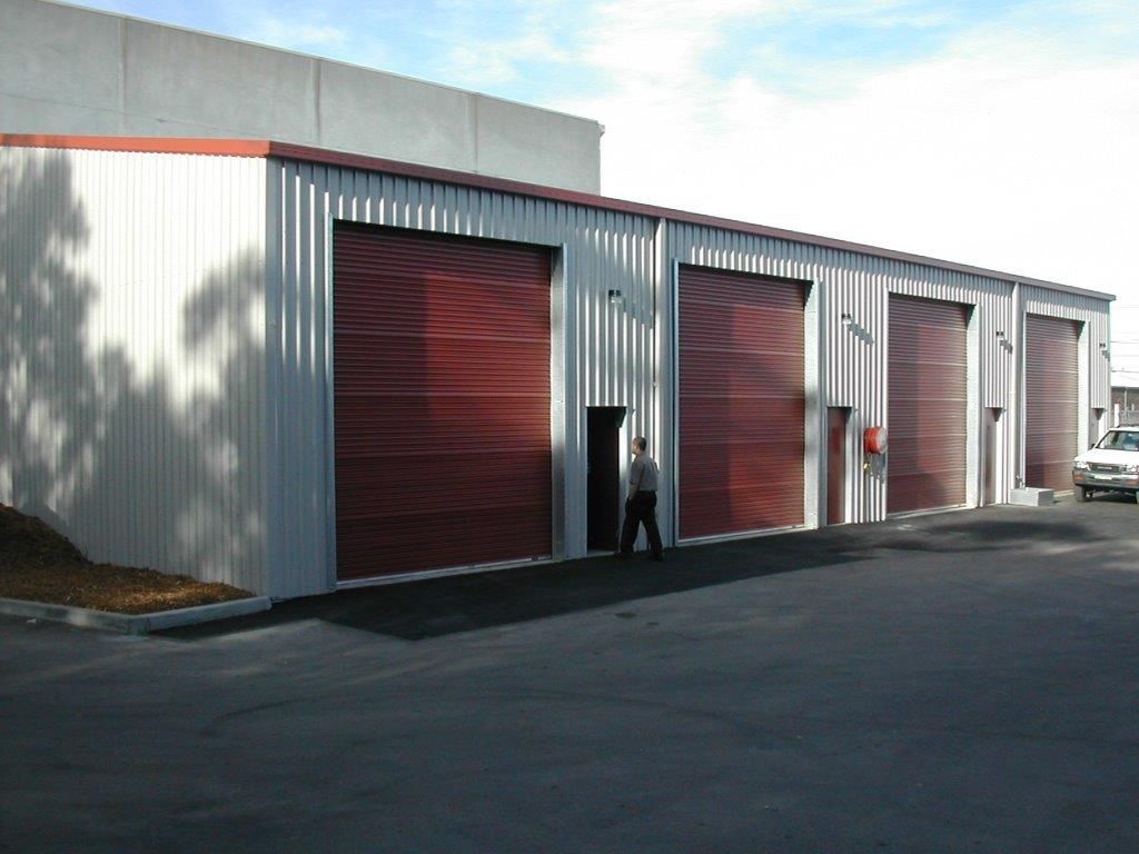 Industrial building with red roll-up doors — More Than Garages Pty Ltd–Ranbuild Tamworth in Taminda, NSW