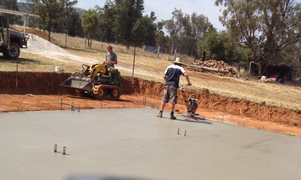 Workers smoothing fresh concrete on a road edge — More Than Garages Pty Ltd–Ranbuild Tamworth in Taminda, NSW