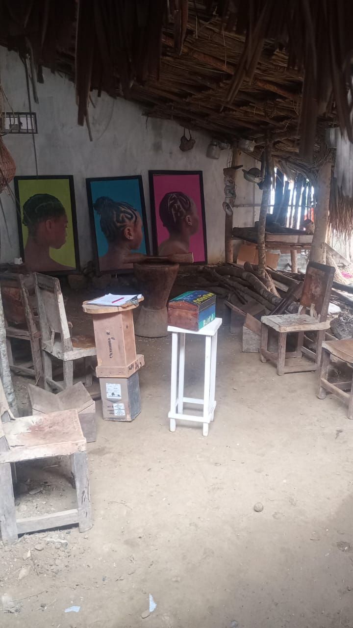 Una habitación con sillas, mesas y cuadros en la pared.