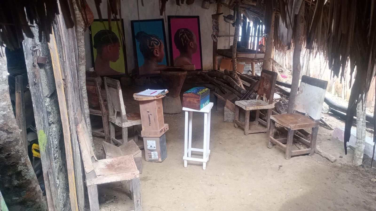 Una habitación con sillas, mesas y cuadros en la pared.