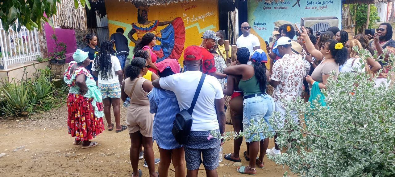 Un grupo grande de personas está parado frente a un edificio.