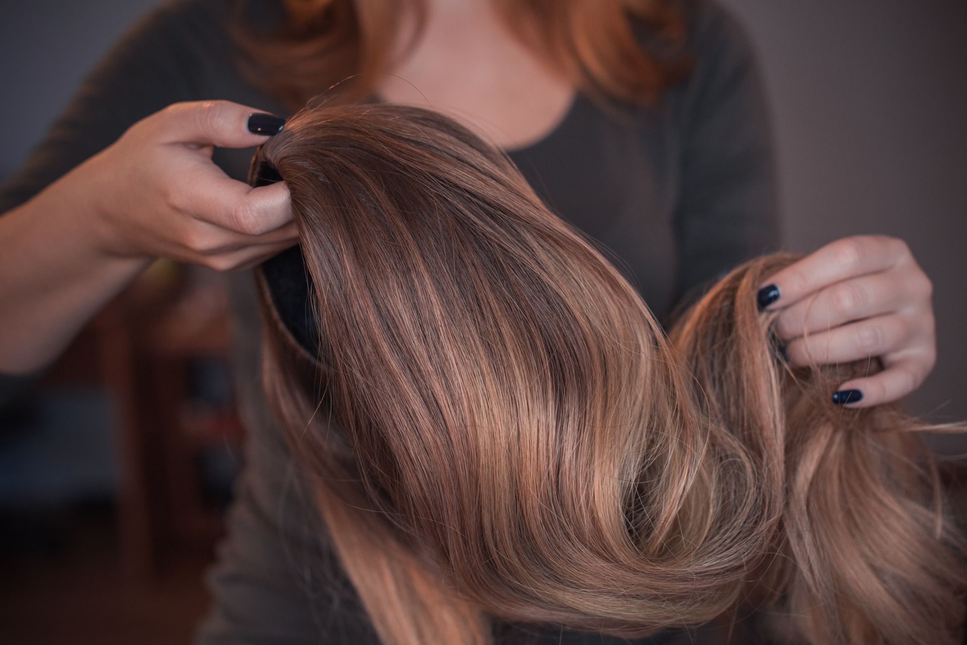 Hands styling long wavy brown hair Hands styling long wavy brown hair