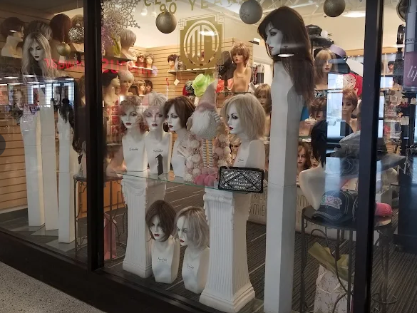 Wigs in various shades of brown, blonde, and black, arranged in a row.