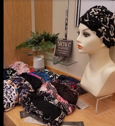 Display of various colorful sun hats, including straw, lavender, and blue.