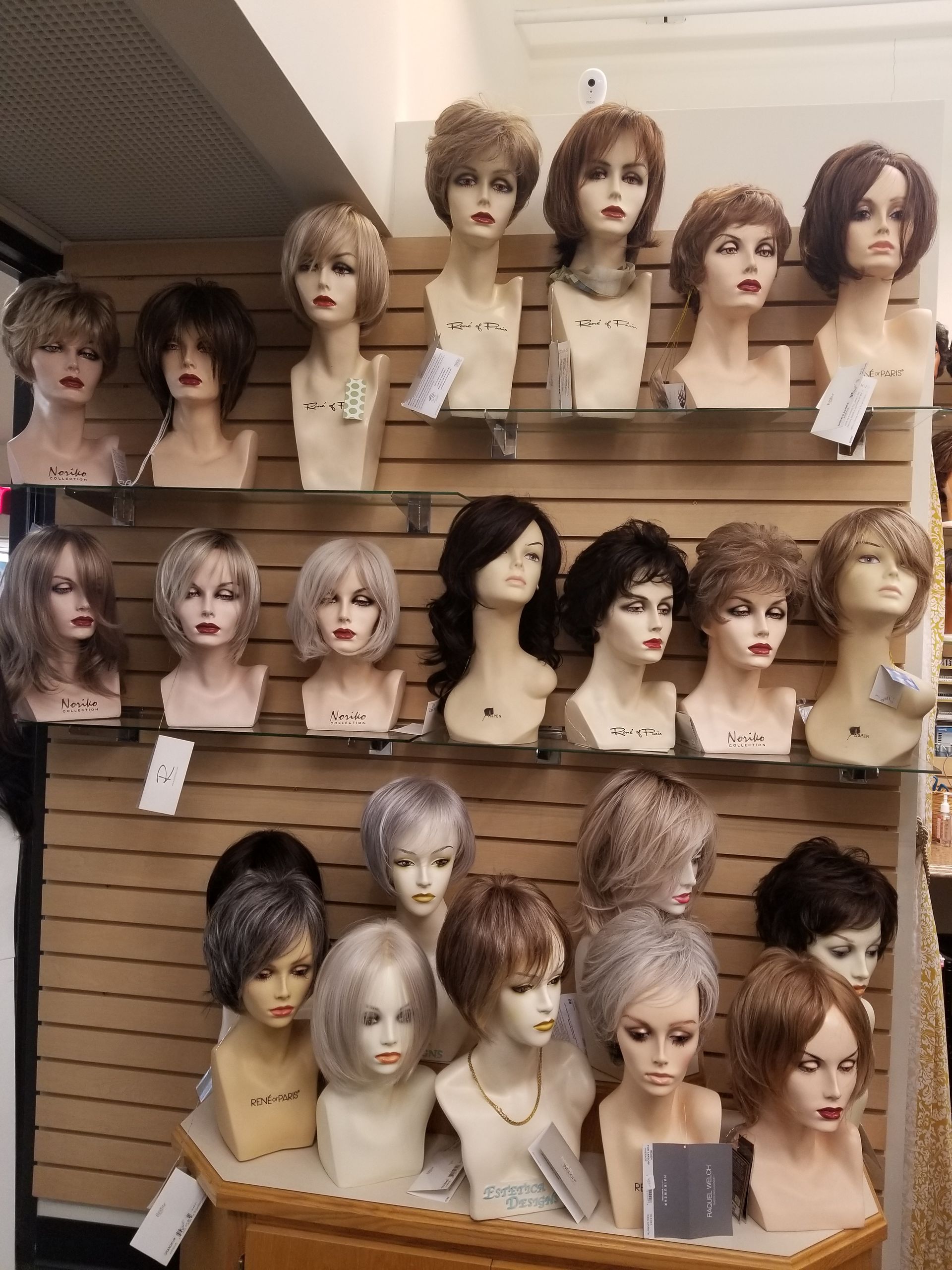 Three mannequin heads with wigs: ombre blonde, brown bob, and long brown.