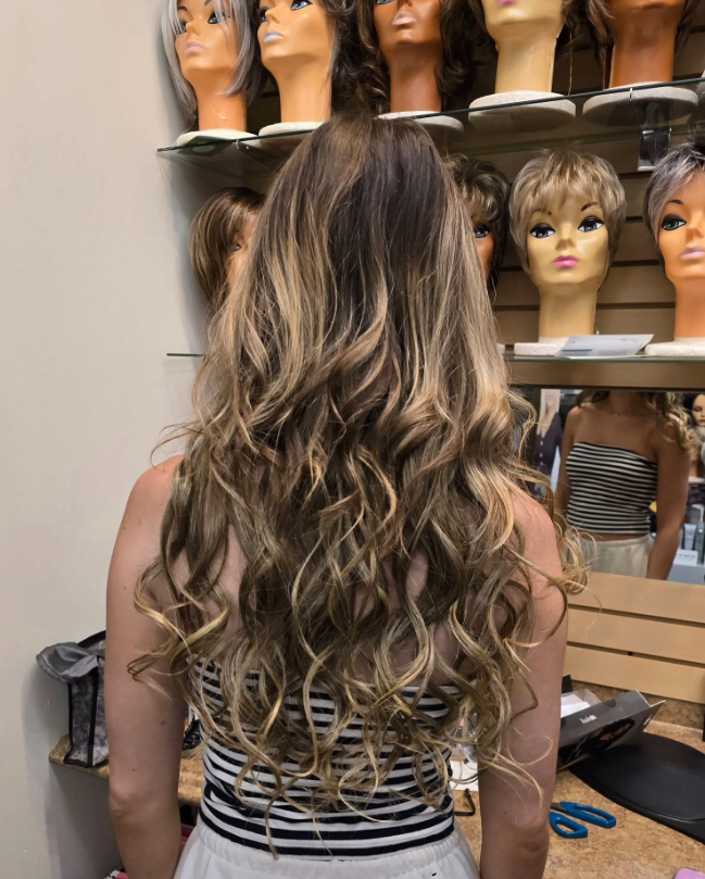 Interior shop display of scarves, clothing and accessories. Mannequin wearing a headscarf.