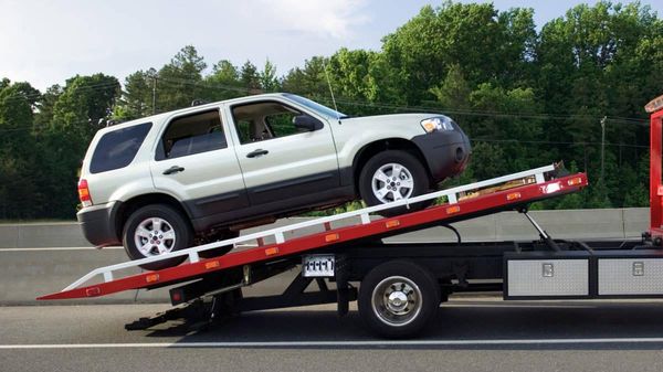 silver suv being loaded onto flatbed truck