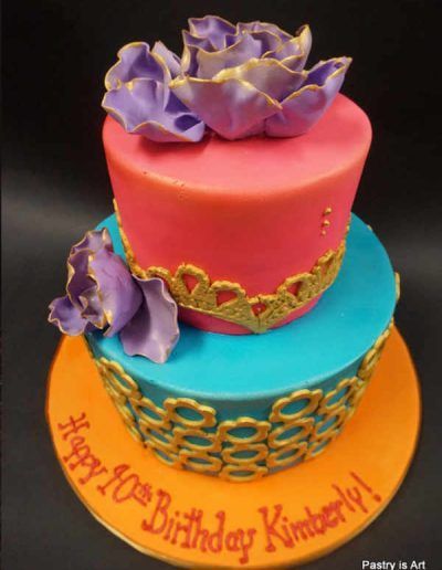 A colorful birthday cake with the name kimberly on it