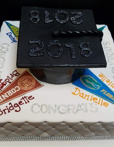 A cake with a graduation cap on top that says congrats