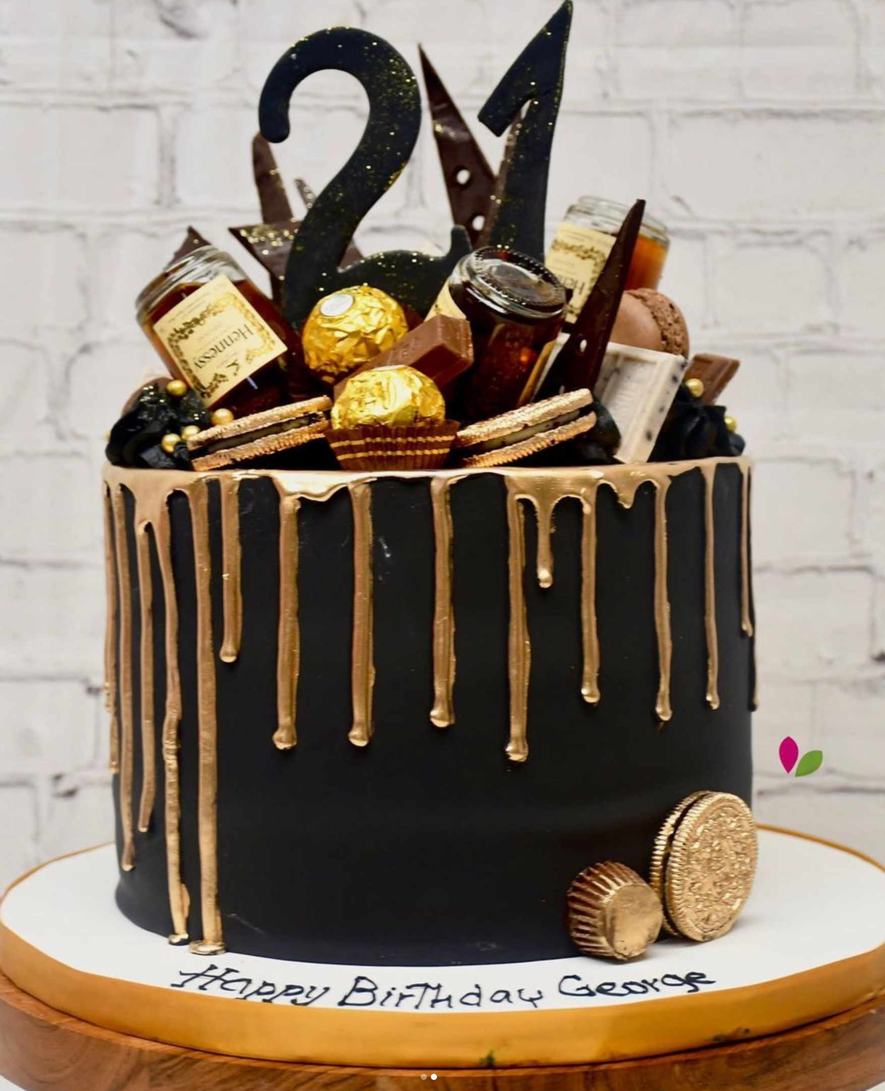 A black and gold birthday cake with the number 21 on top