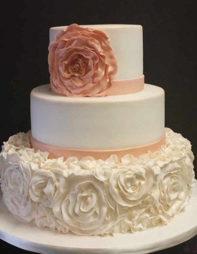 A white cake with a pink flower on top
