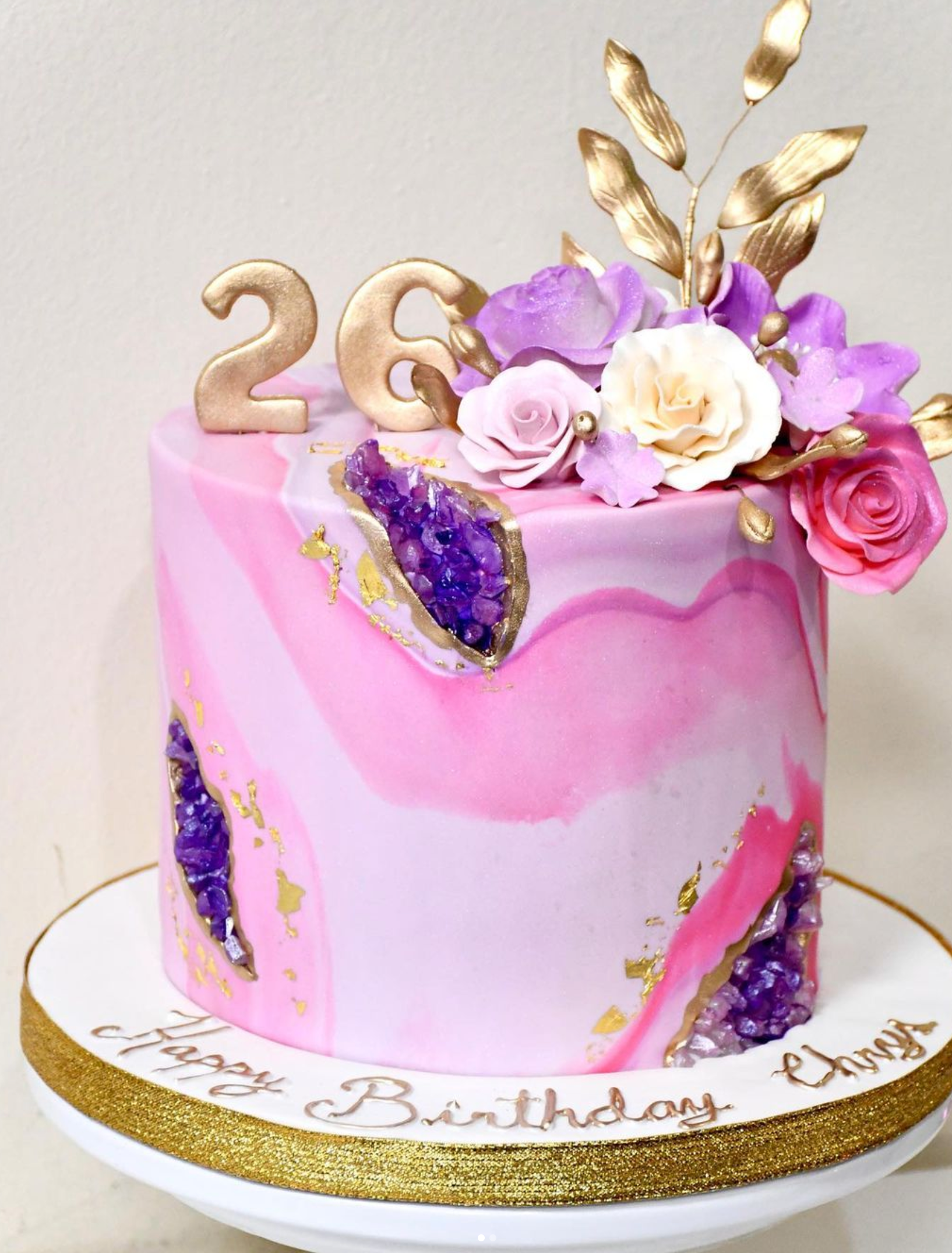 A pink and purple birthday cake with the number 26 on top.