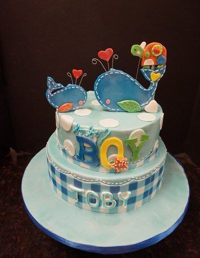 A baby shower cake for a boy with whales on top