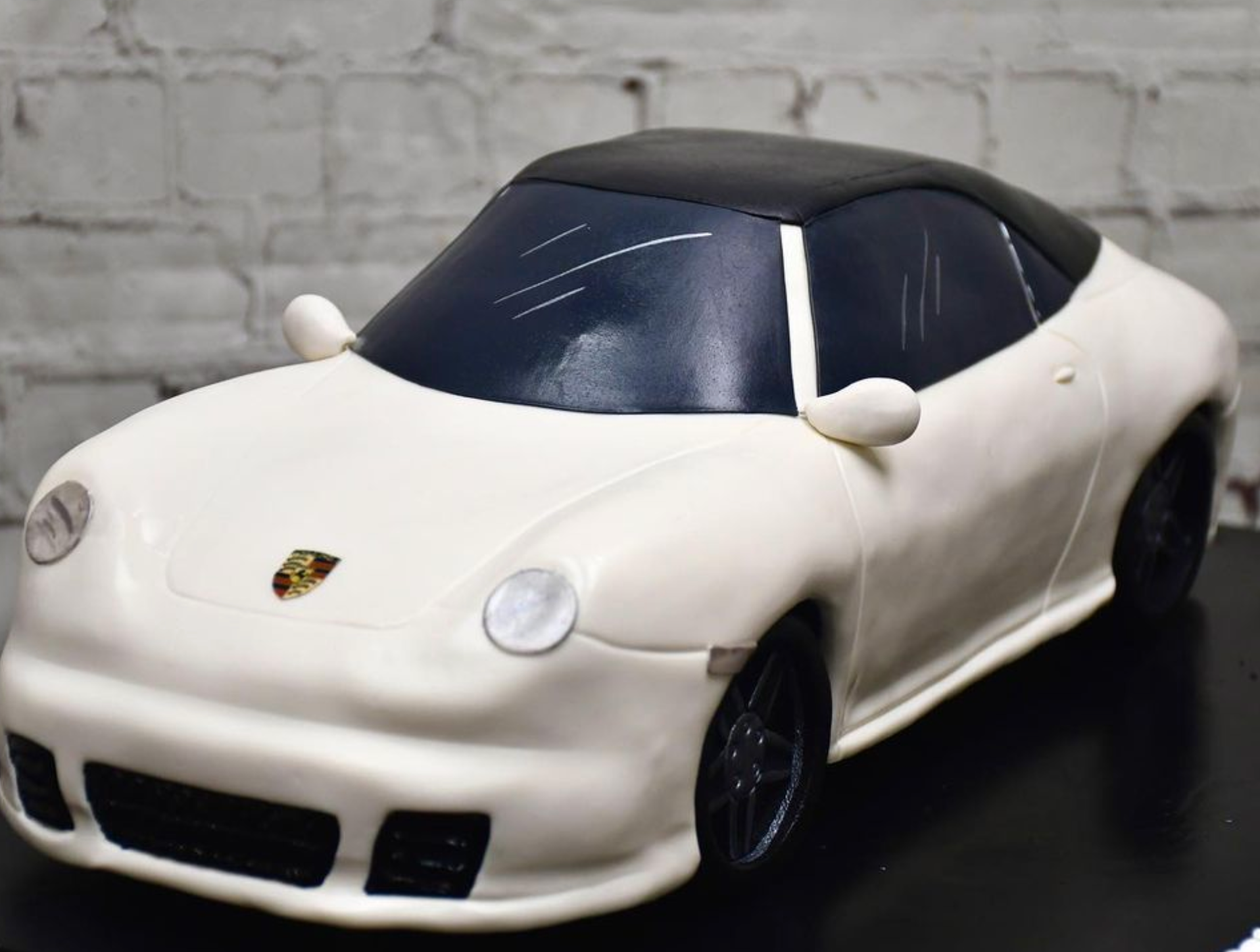 A white car with a black top is on a table