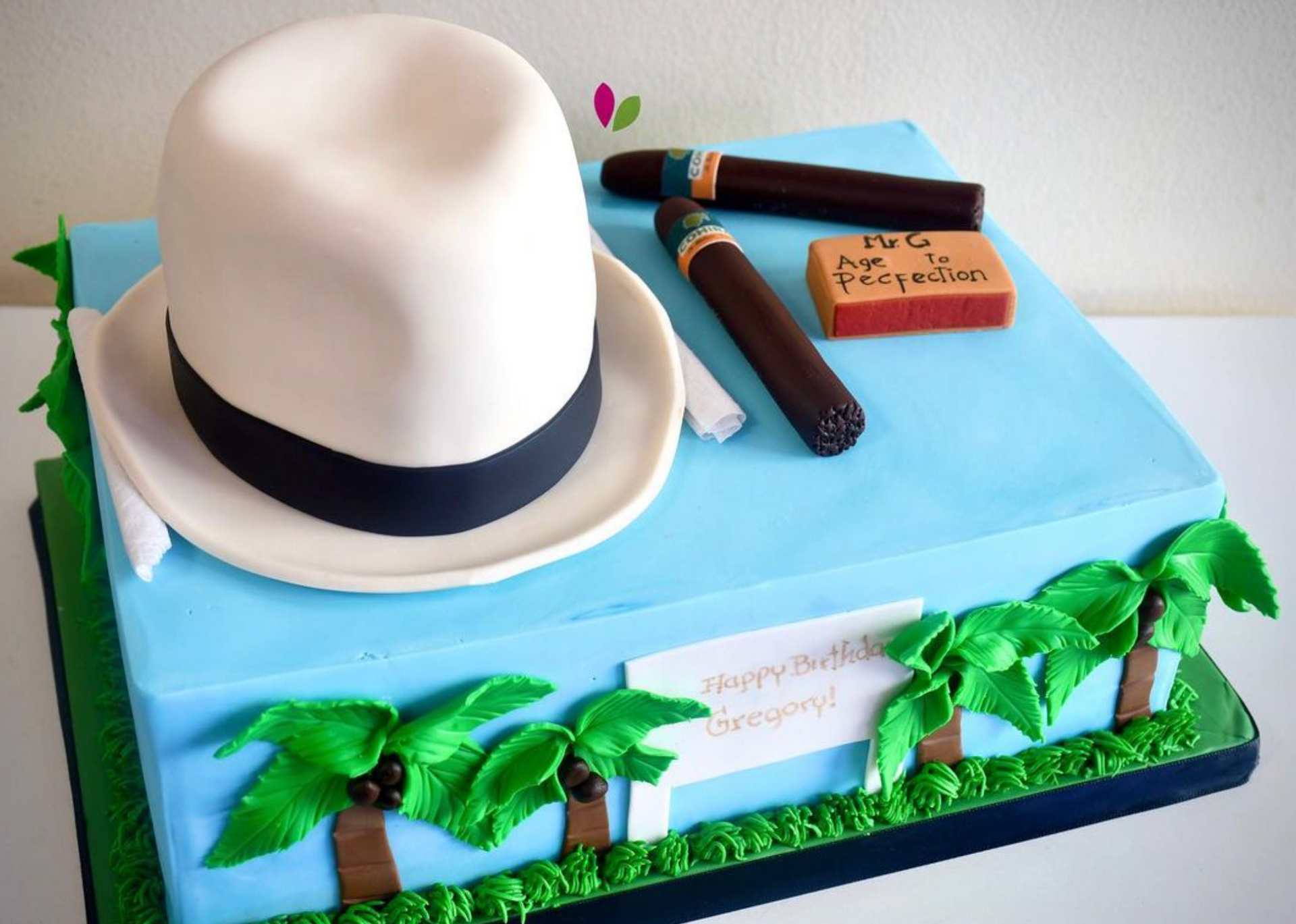 A birthday cake with a hat and cigars on it