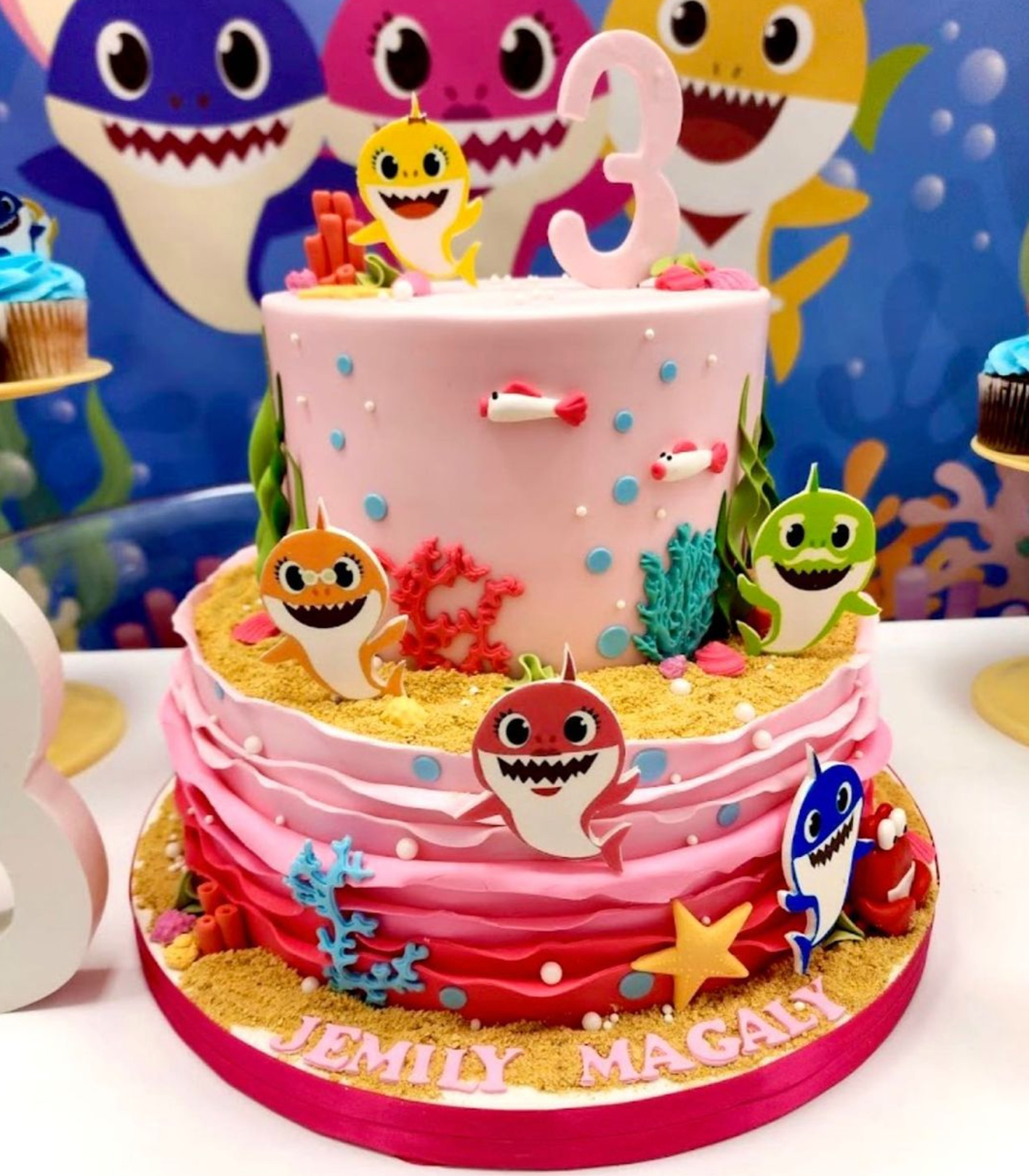 A baby shark cake with the name emily on it