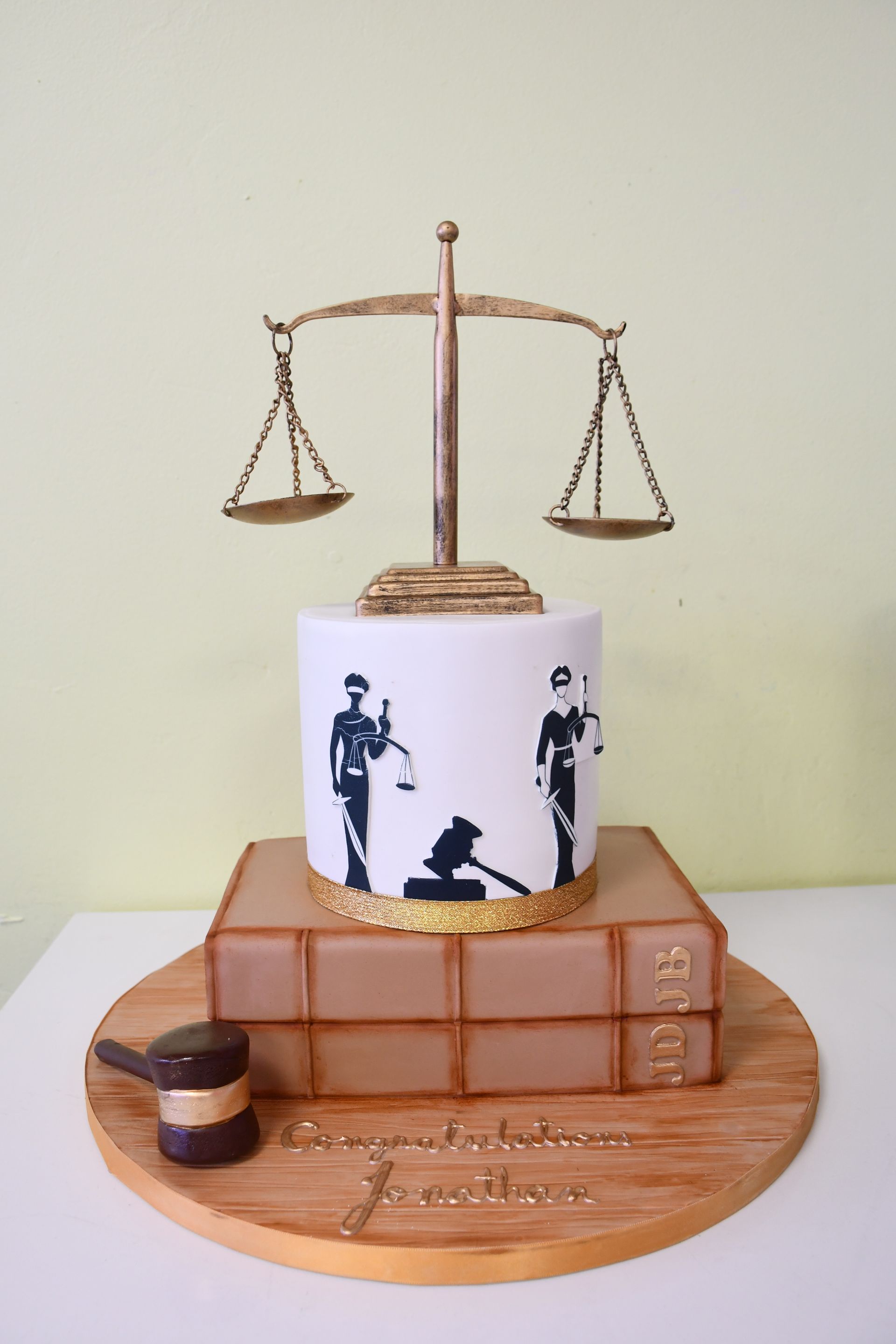 A cake with a scale of justice on top of a stack of books