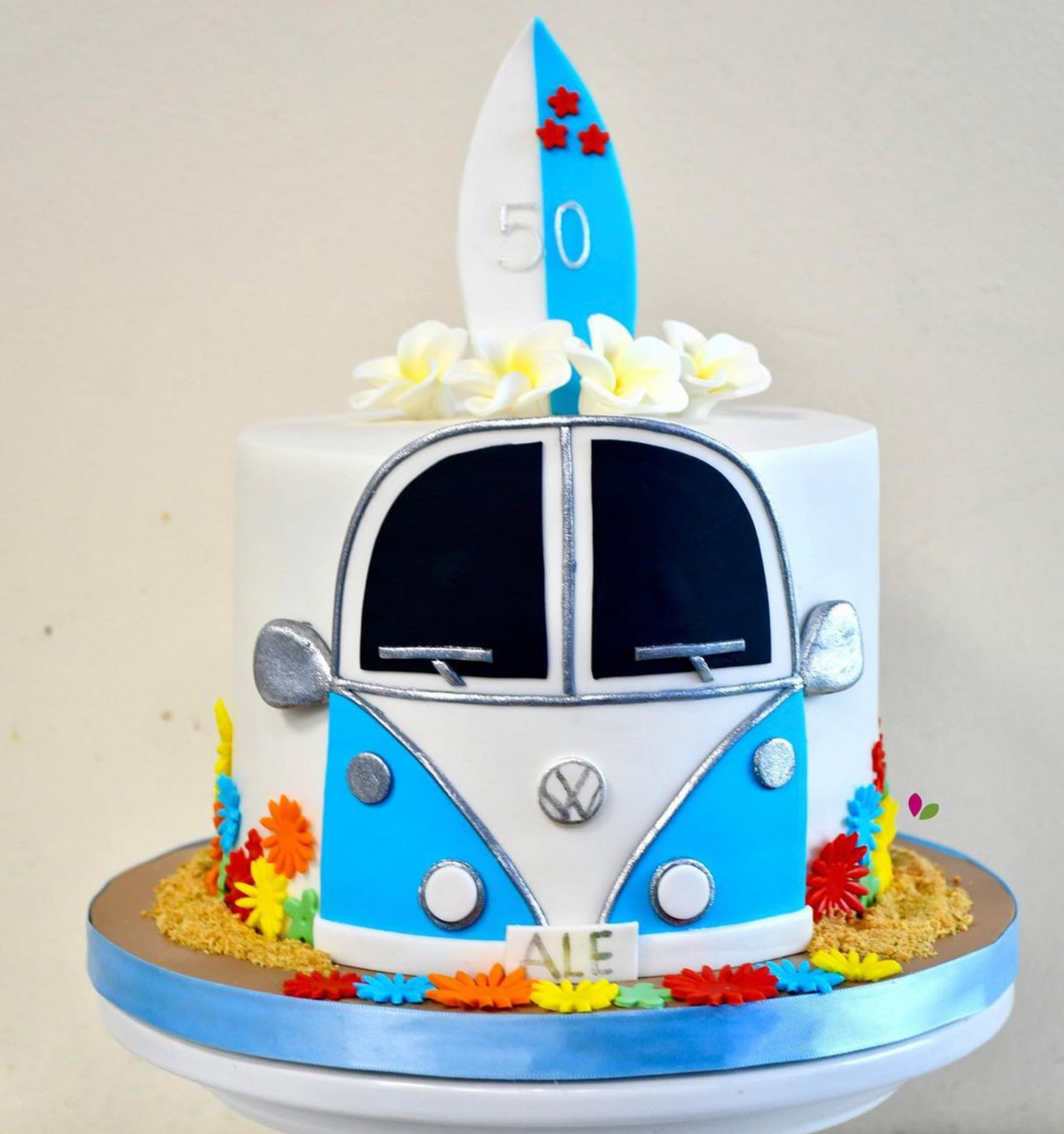 A cake with a vw bus and a surfboard on top