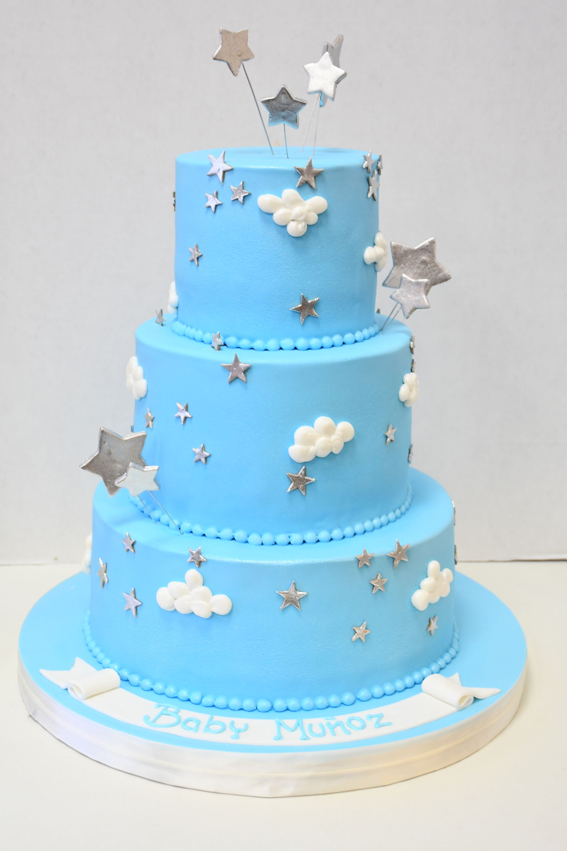 A blue cake with clouds and stars on it