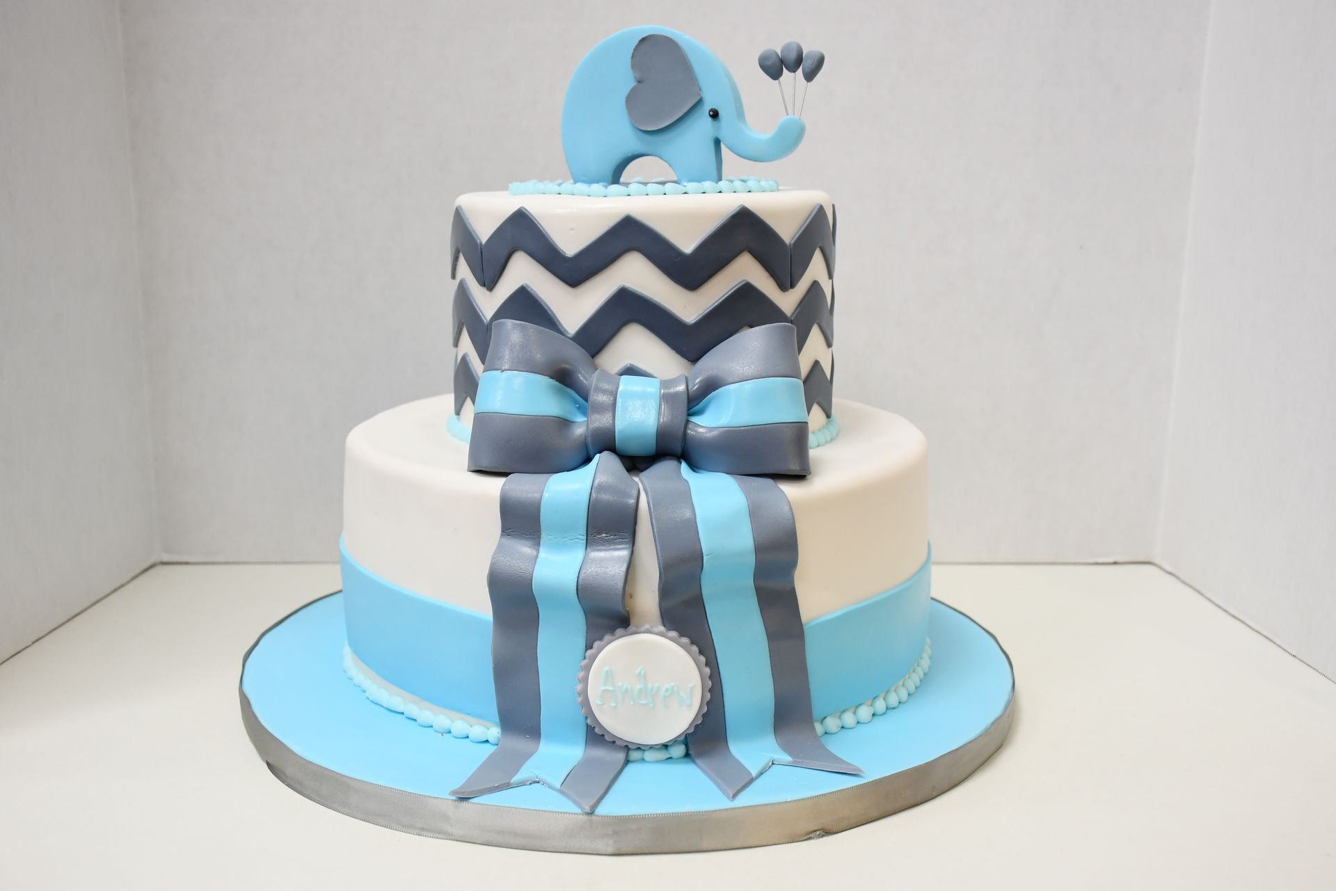 A blue and white cake with an elephant on top