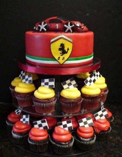 A ferrari cake surrounded by cupcakes and checkered flags
