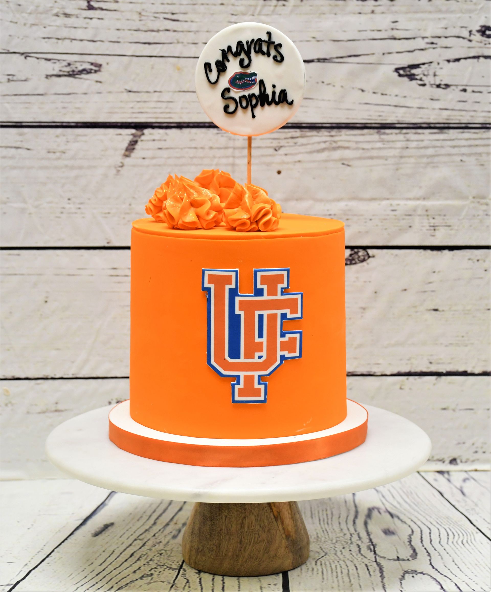 An orange cake with the letter u on it