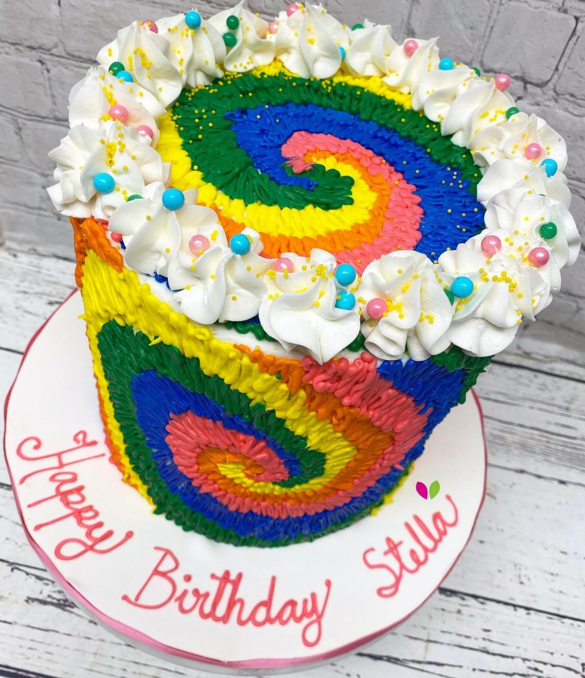 A birthday cake for stella with a rainbow design