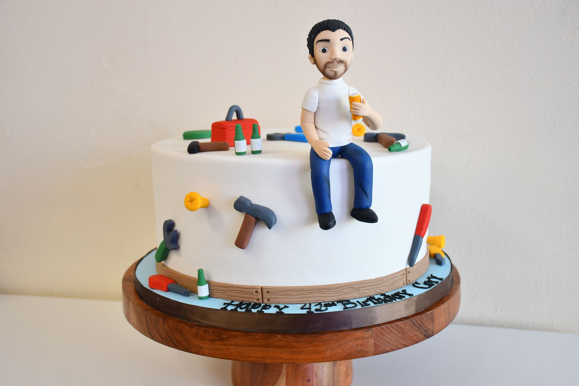 A cake with a man sitting on top of it
