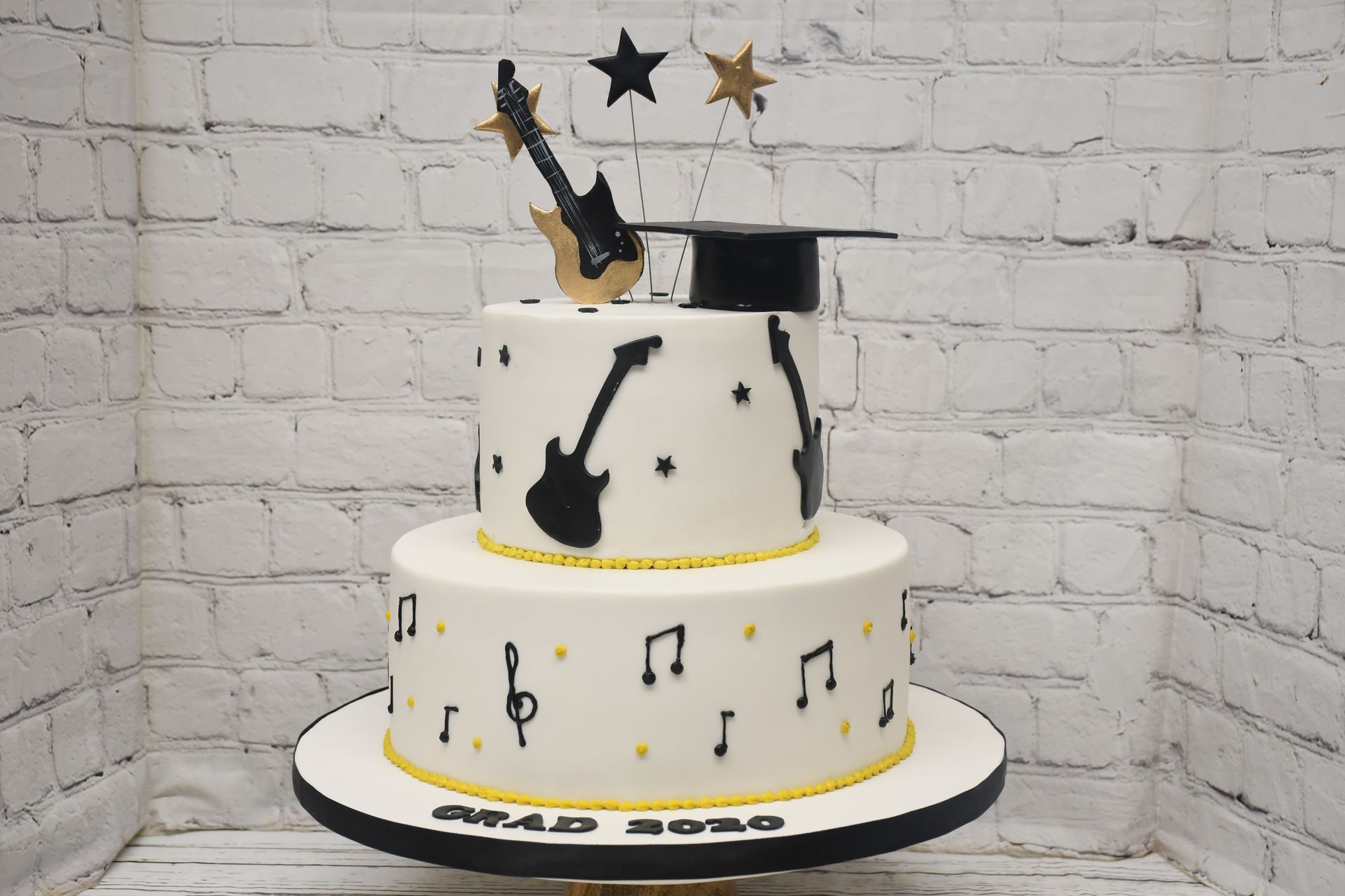 A cake with a graduation cap and guitar on it