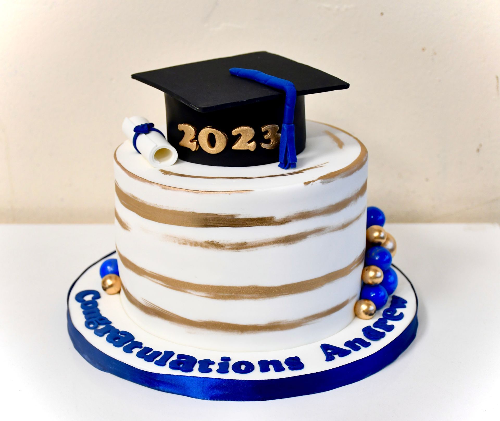 A cake with a graduation cap on top that says 2023