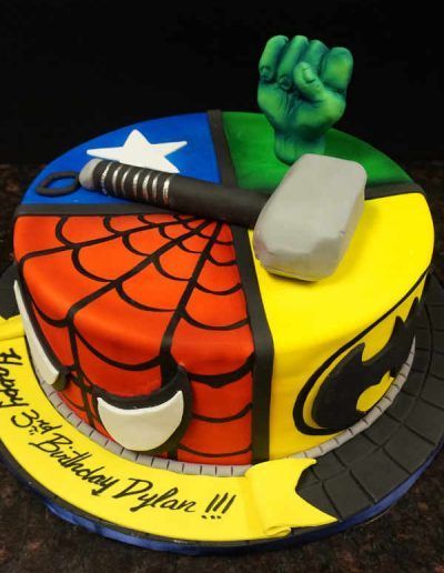 A birthday cake with spiderman hulk thor and batman on it