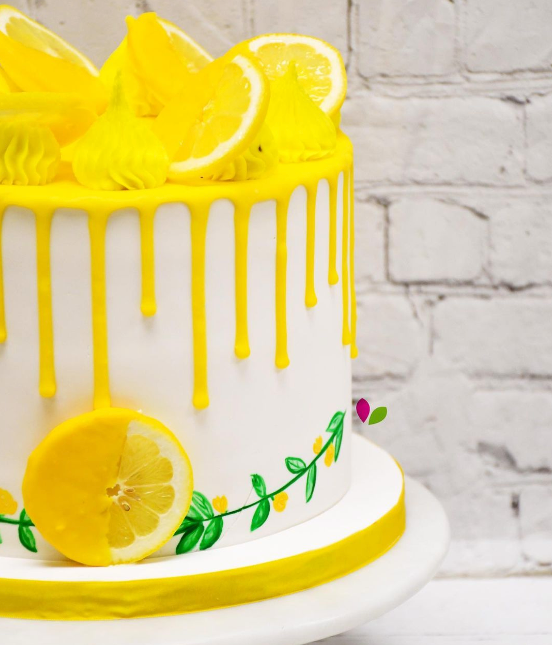 A white cake with yellow frosting and lemon slices on top