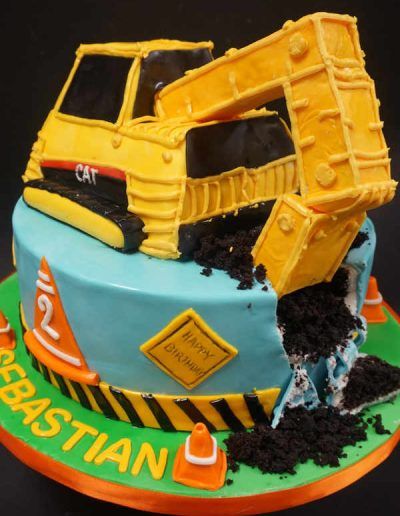 A cake with a cat excavator on top of it