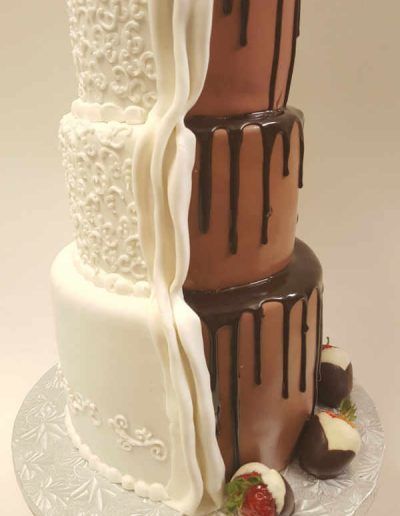 A white and chocolate cake with strawberries on top