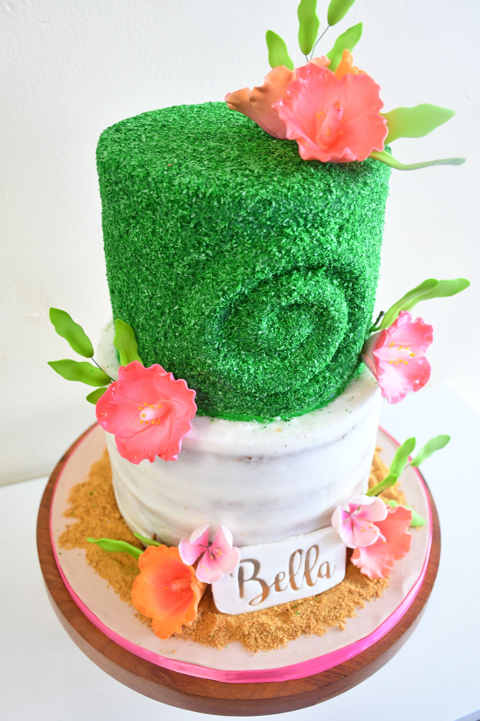 A cake with flowers and grass on top of it.