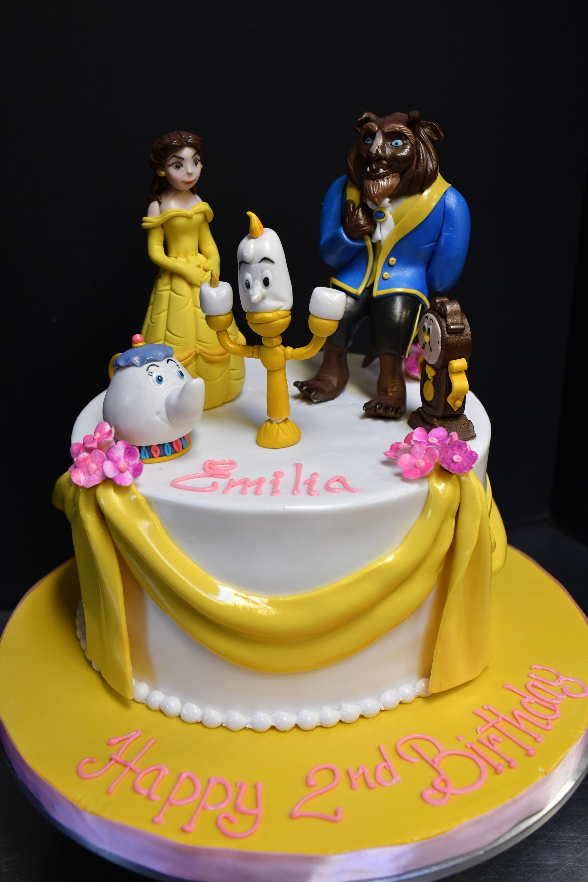 A cake with a beauty and the beast theme on it.