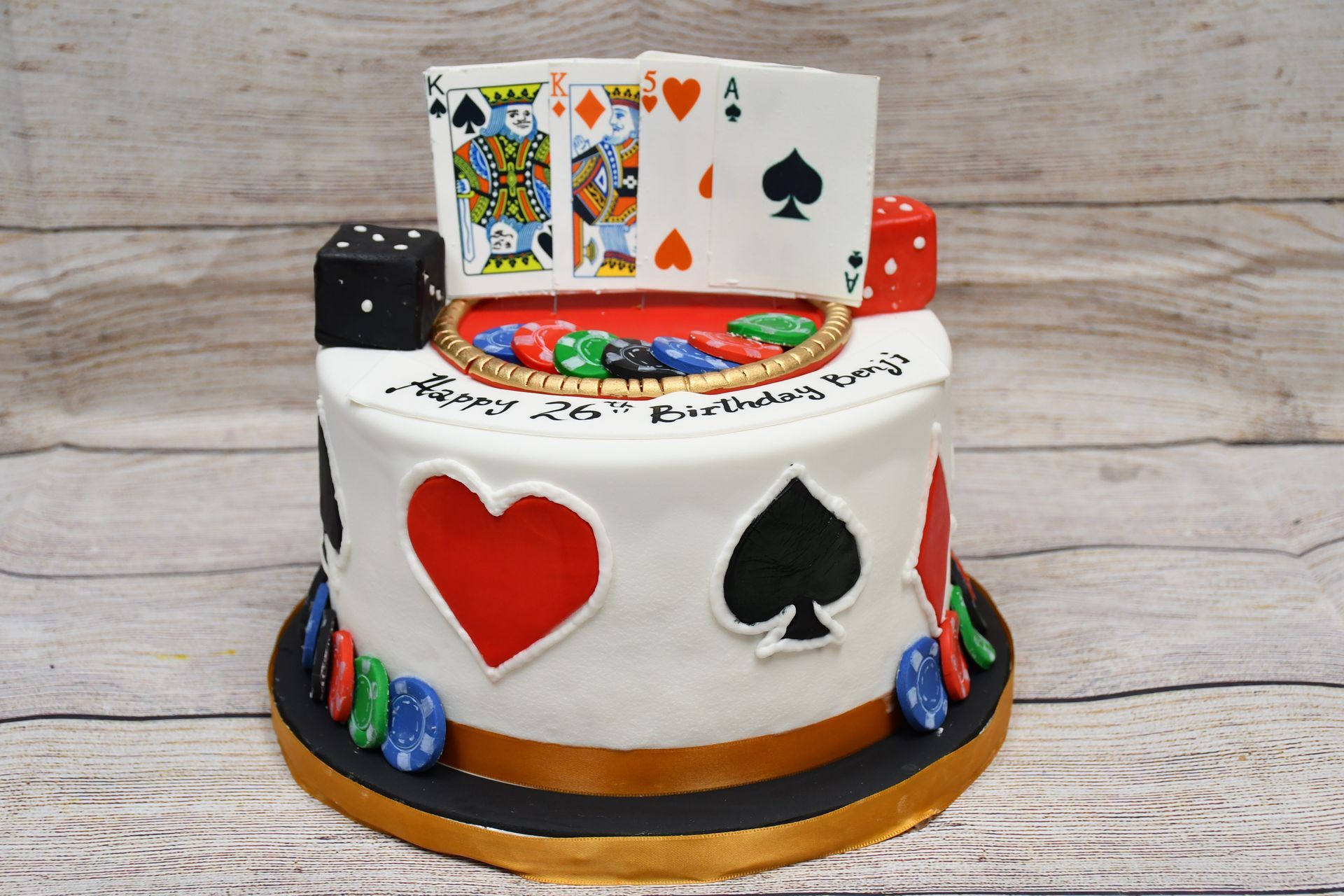 A cake with playing cards dice and chips on it