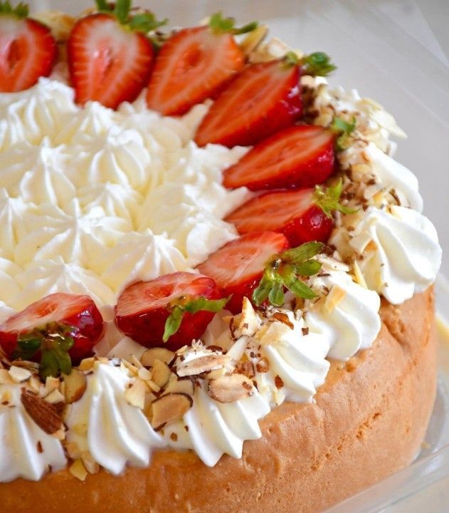 A cake with whipped cream and strawberries on top