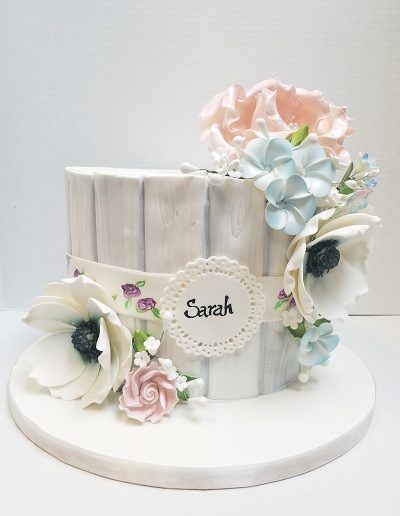 A cake with flowers and the name sarah on it
