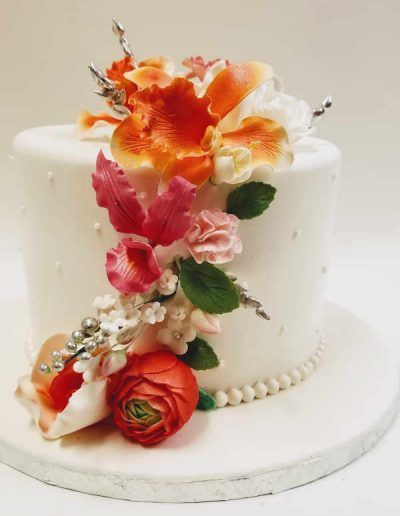 A white cake with flowers and pearls on it
