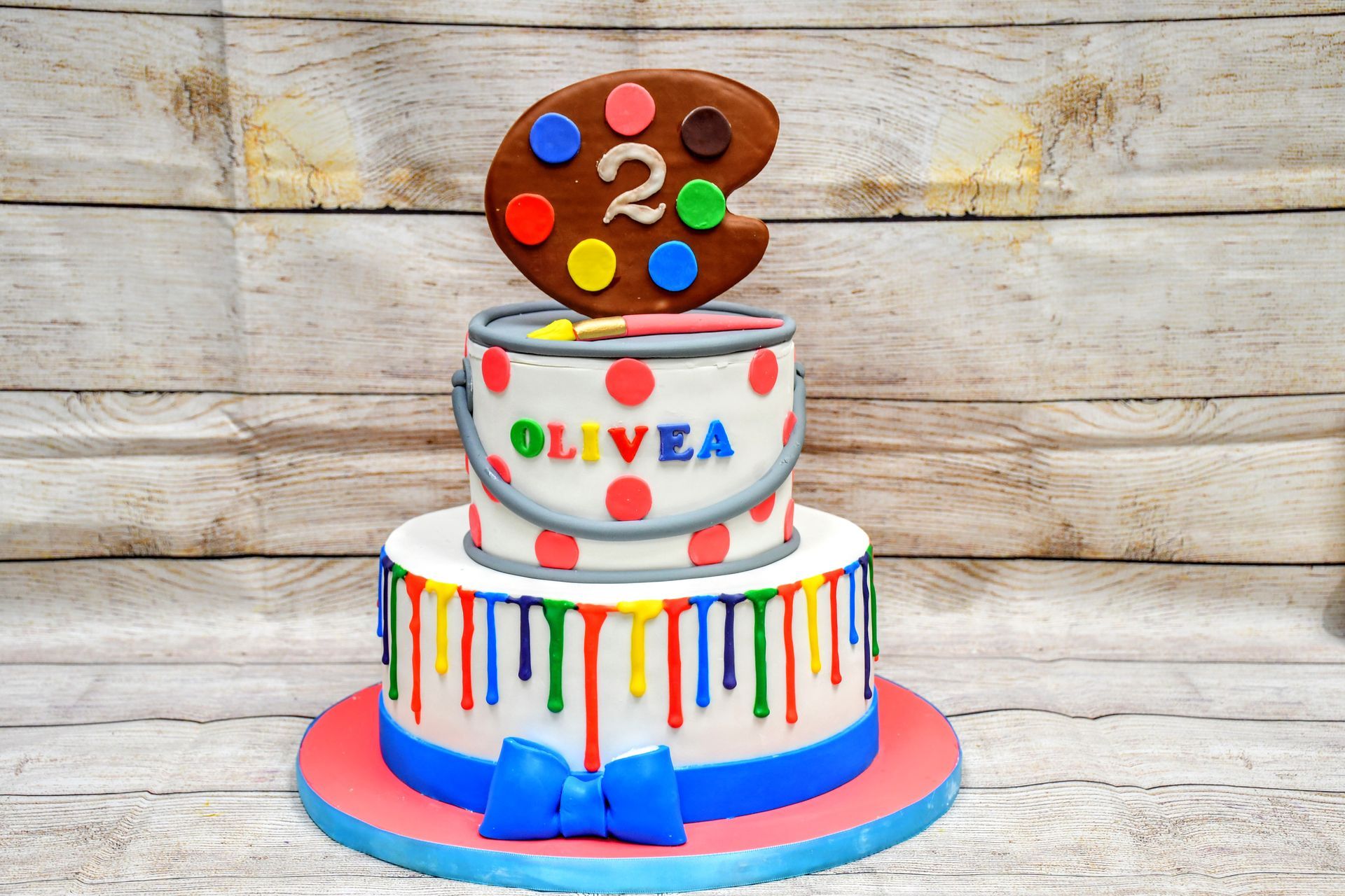 A birthday cake with a bucket of paint and a palette on top.