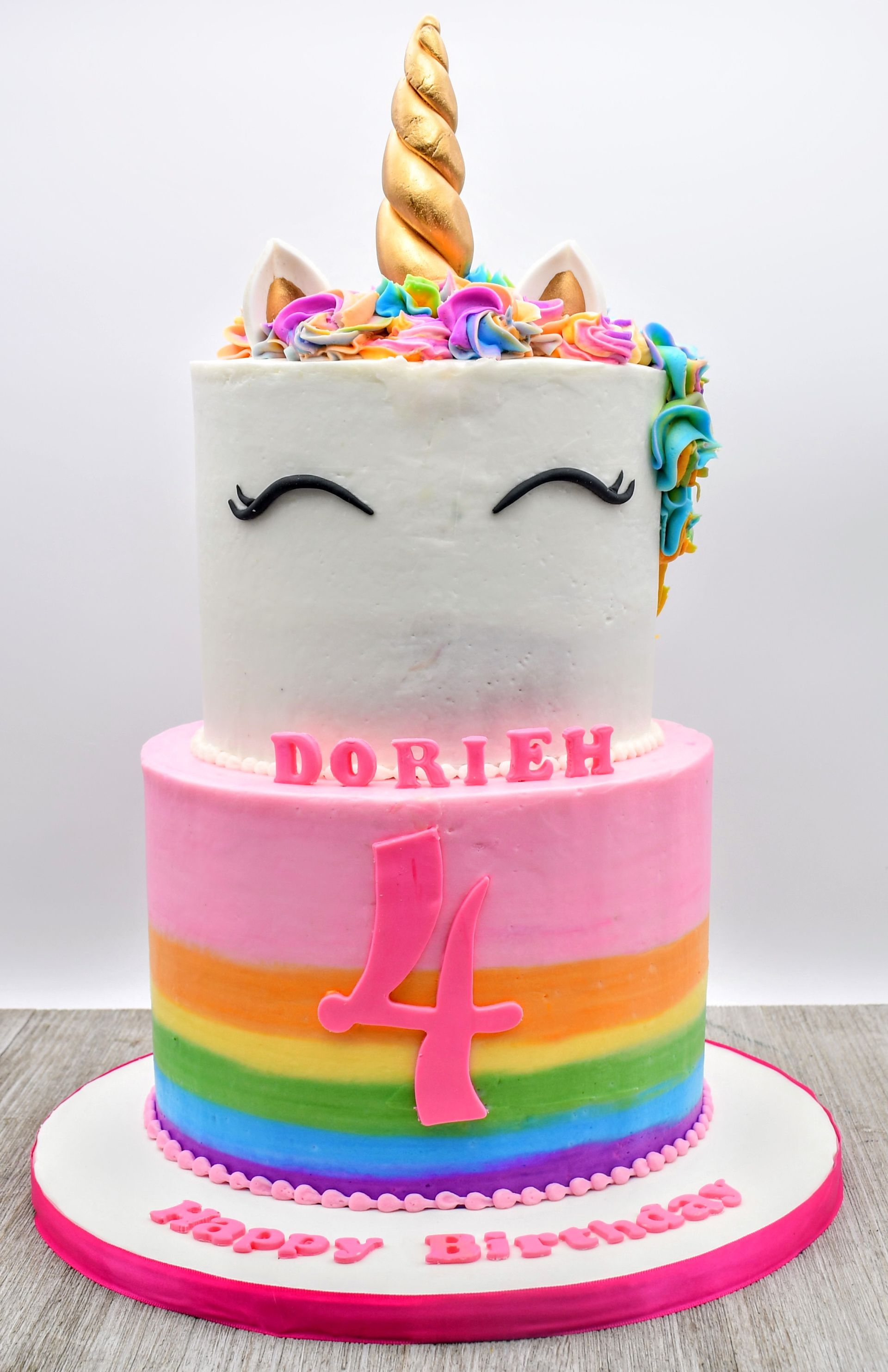 A birthday cake for a girl with a unicorn on top of it.