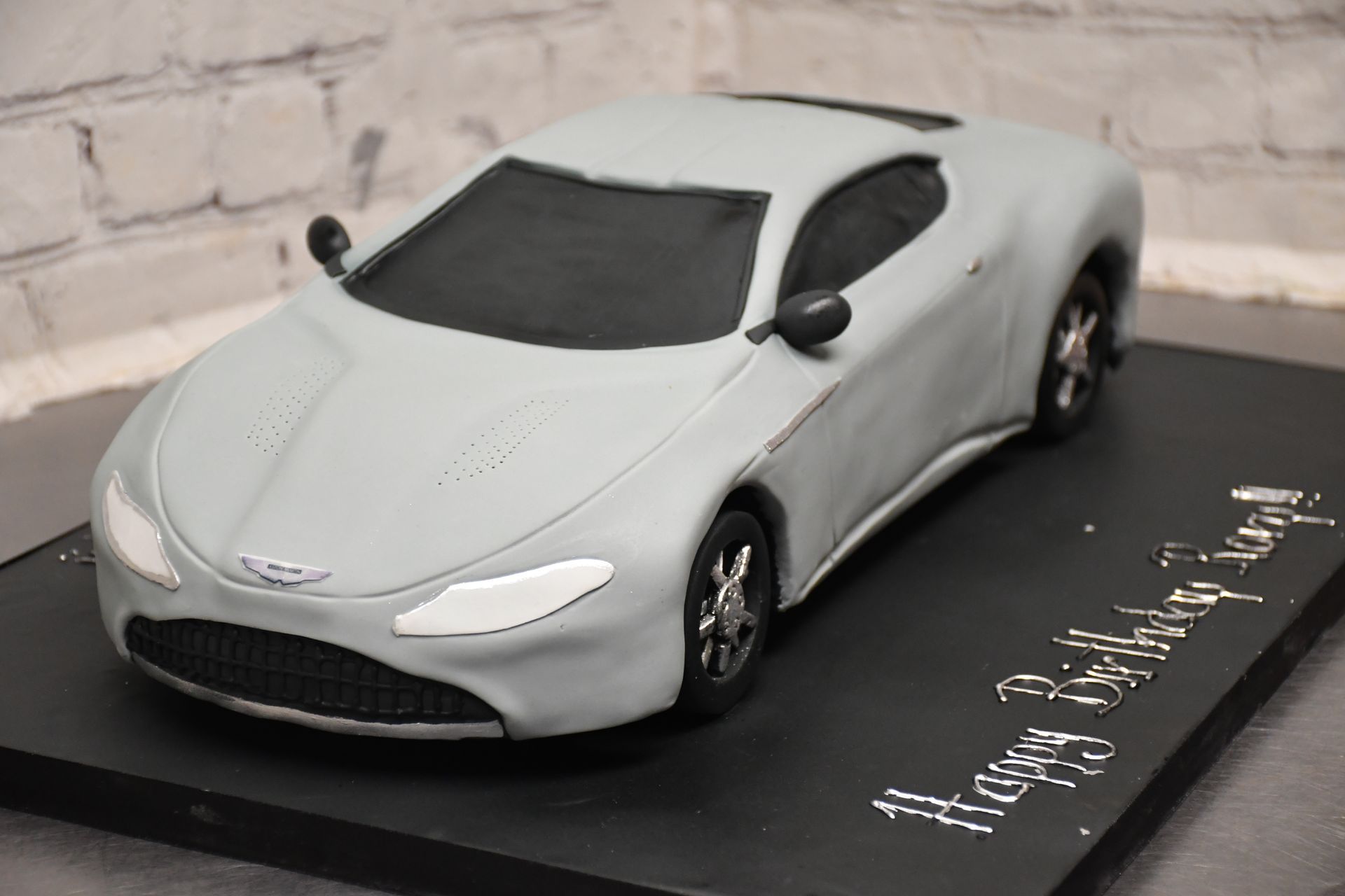 A cake in the shape of an aston martin car