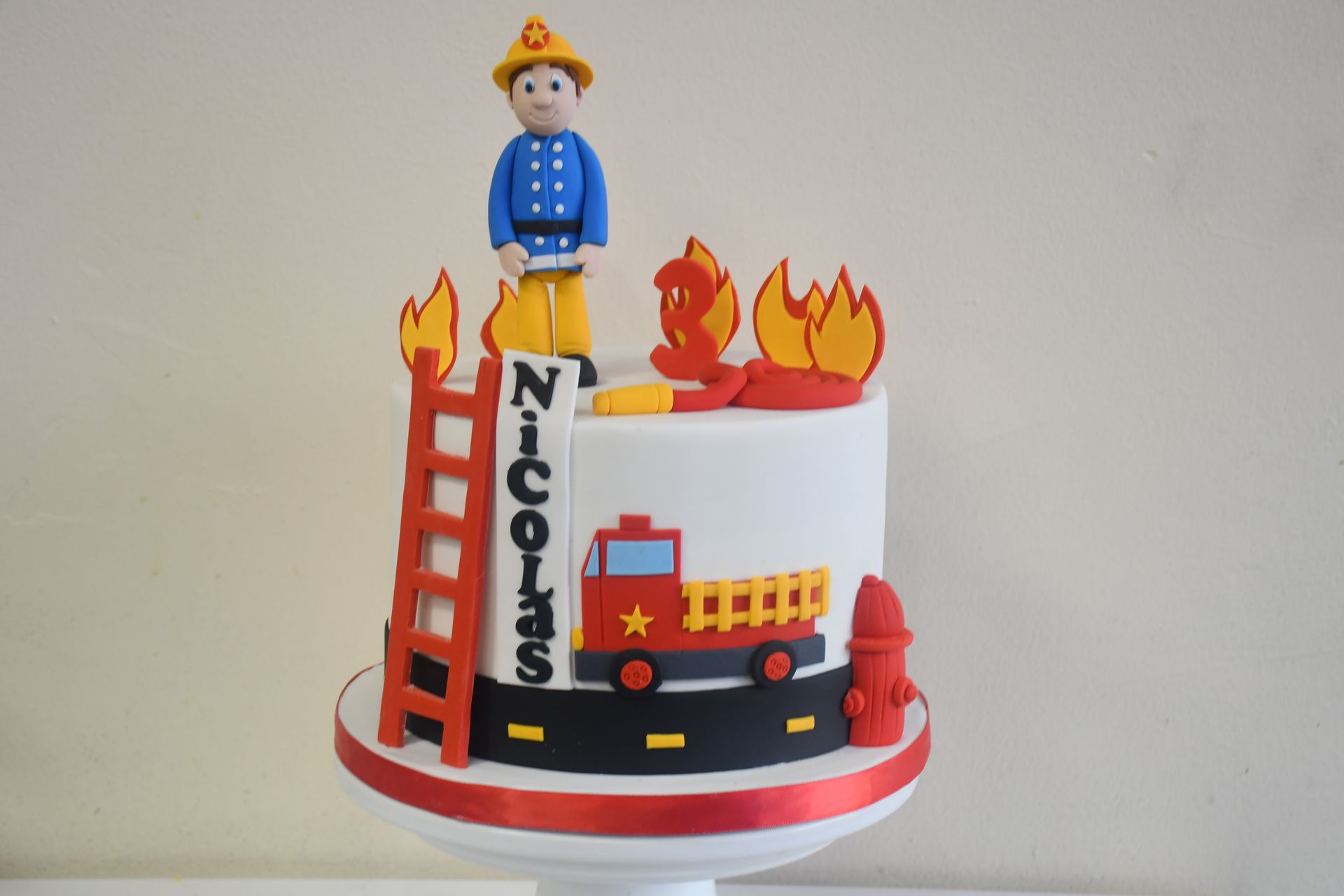 A cake with a fireman on top of it