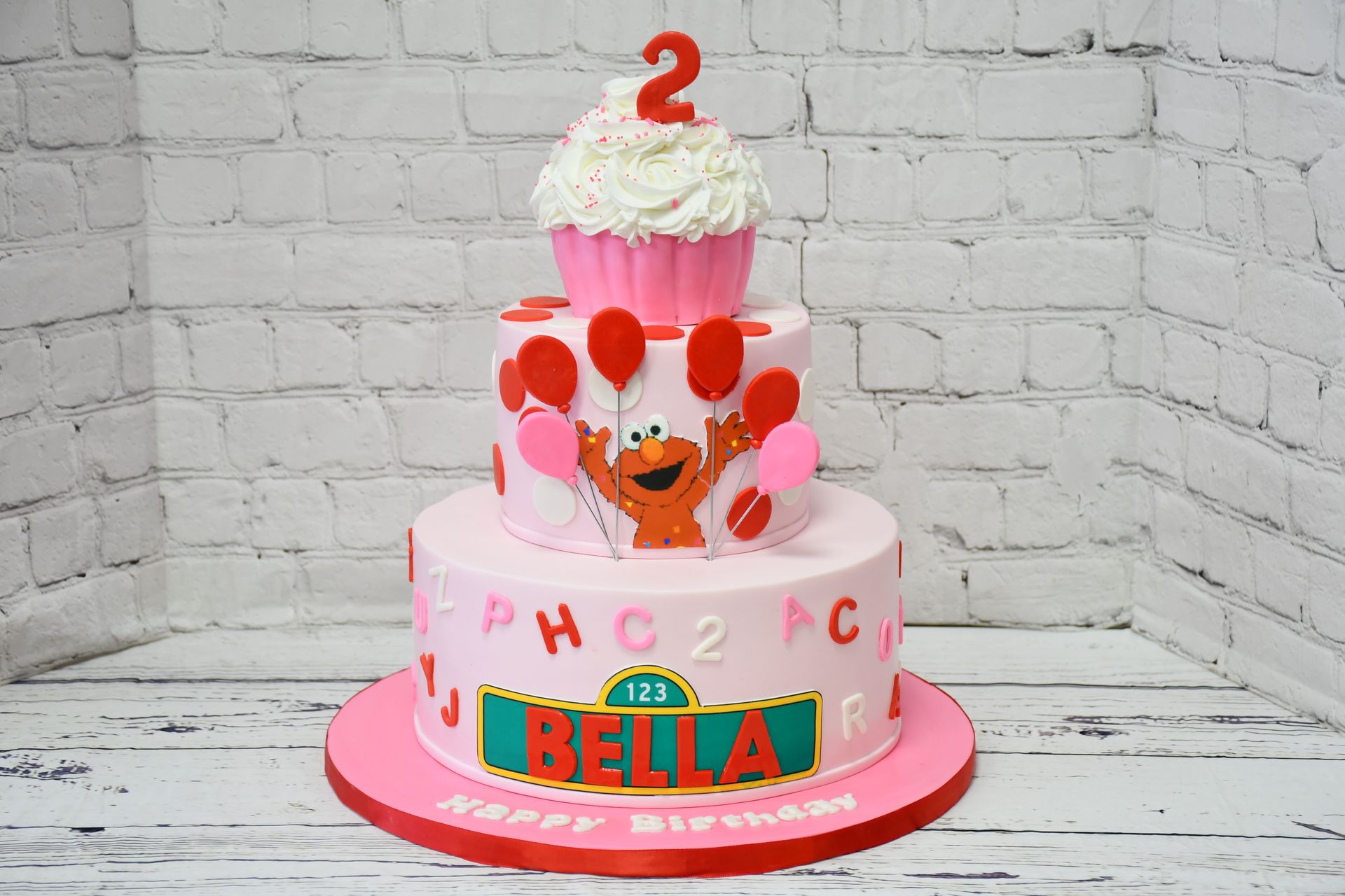 A birthday cake with elmo on it and the number 2 on top
