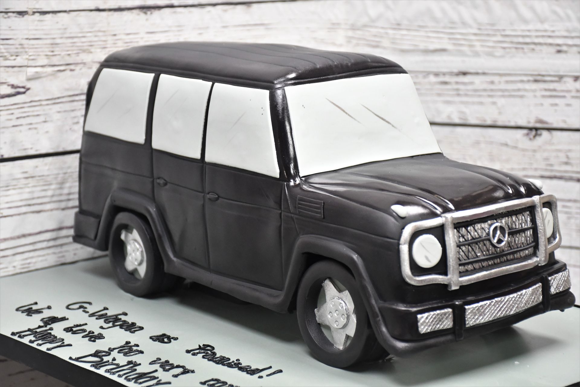 A black and white cake in the shape of a car