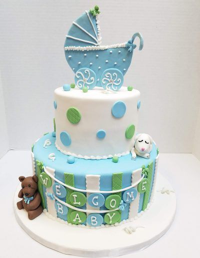 A baby shower cake with a blue stroller on top