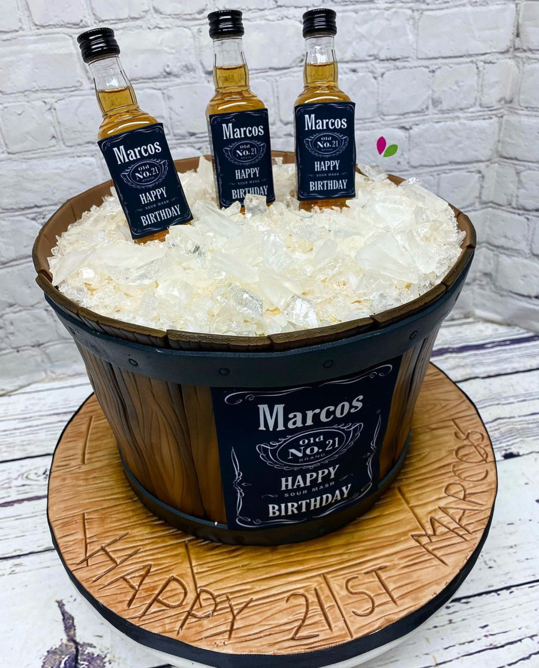 A birthday cake with three bottles of jack daniels in a bucket of ice.