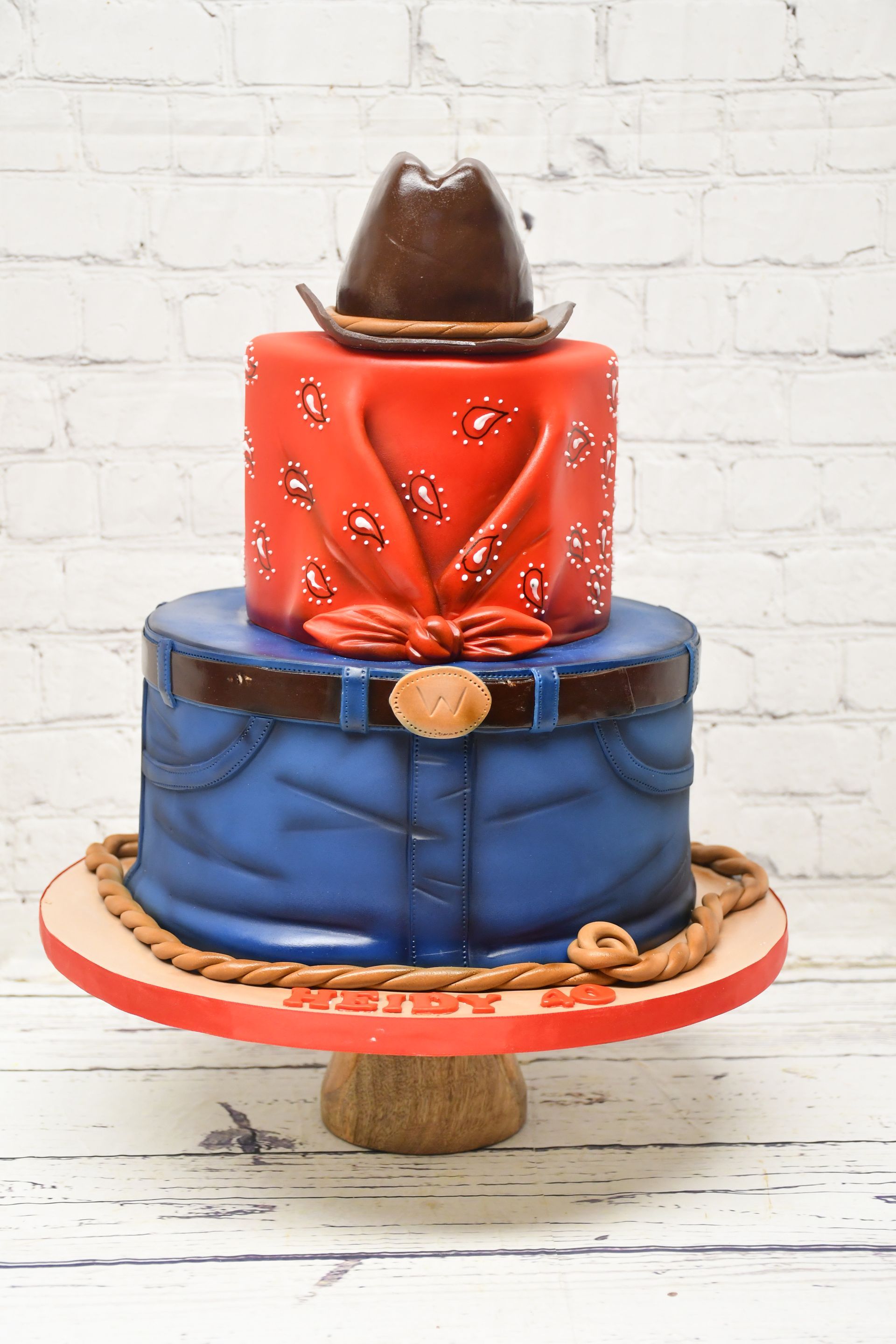 A cake with a cowboy hat and bandana on top of it.