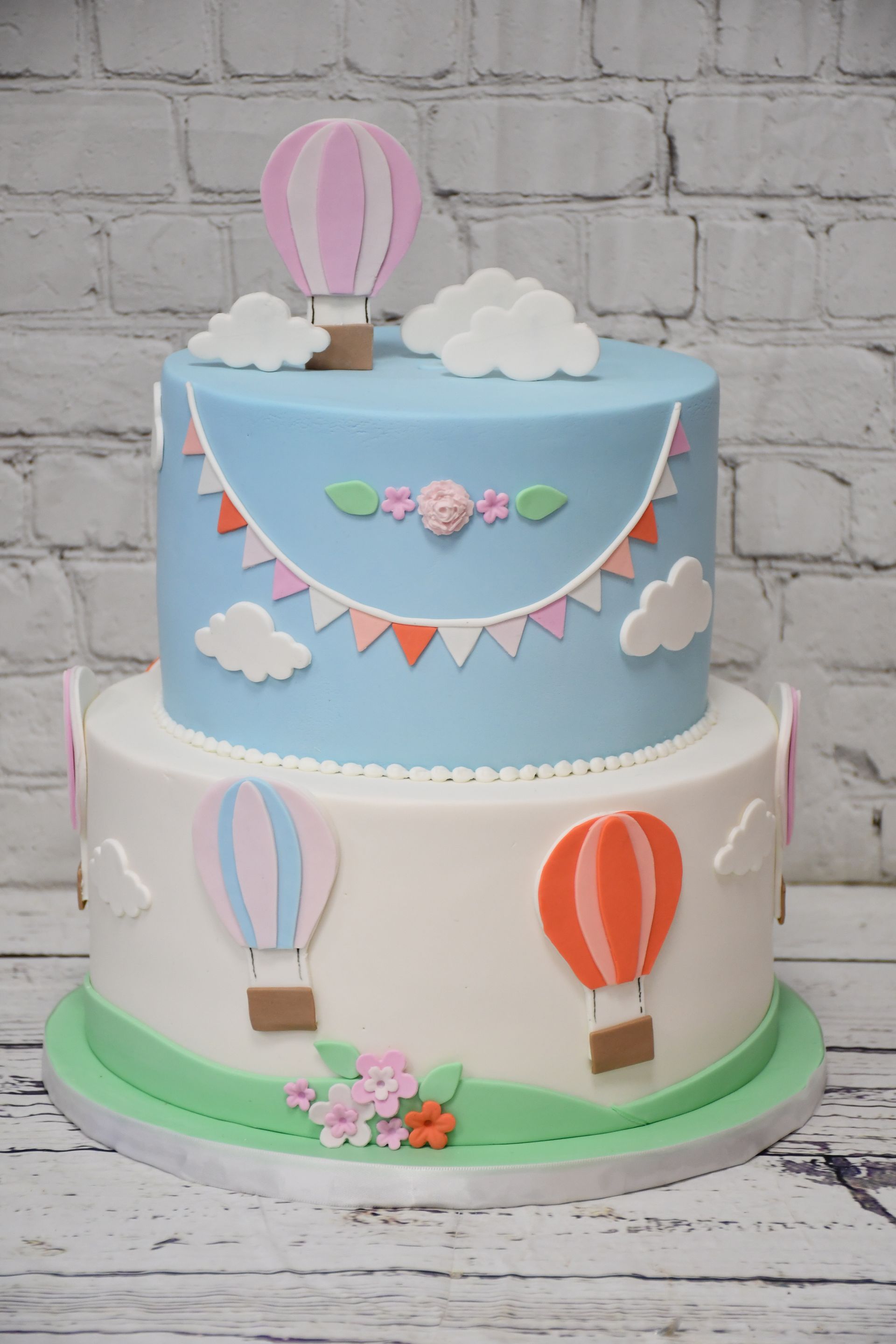 A cake with hot air balloons and clouds on it